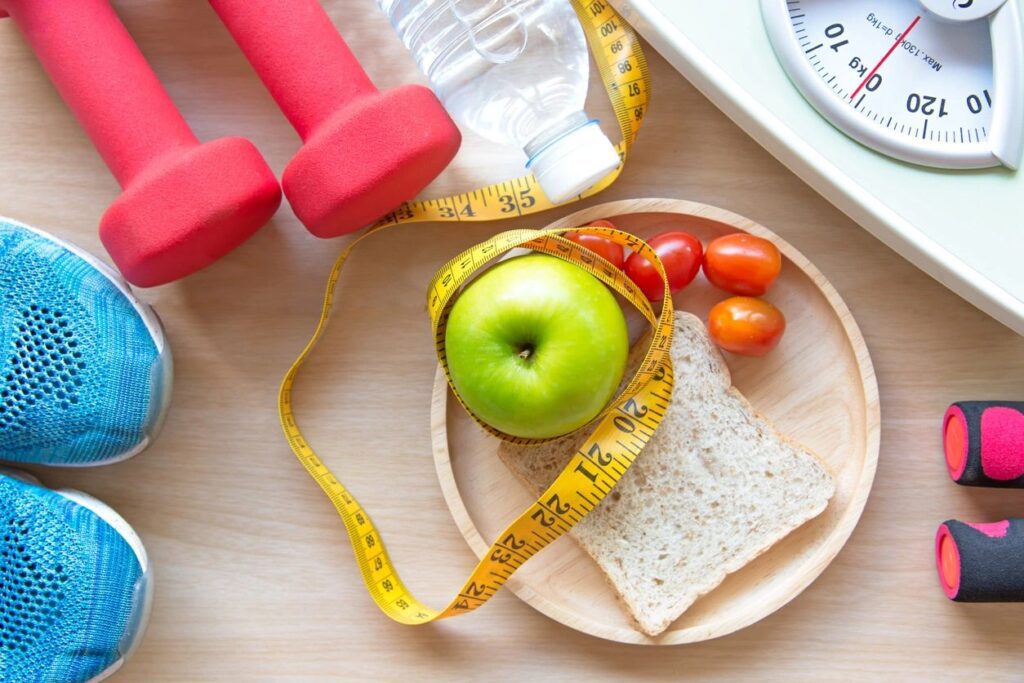 A plate with an apple, crackers and tomatoes on it.