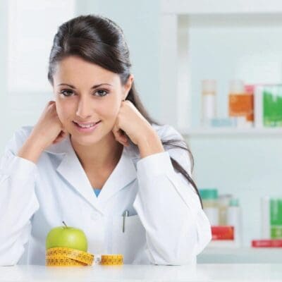 Smiling doctor, apple, measuring tape, healthy.