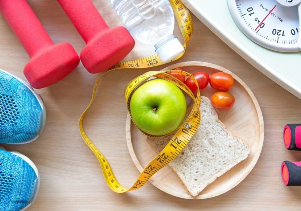 A plate with an apple, crackers and tomatoes on it.